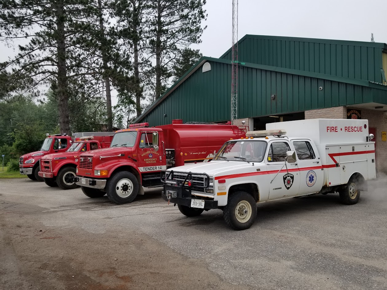 Fleet lined up outside the green Searchmont fire hall: pumpers, Tender 14 and the Fire Rescue truck